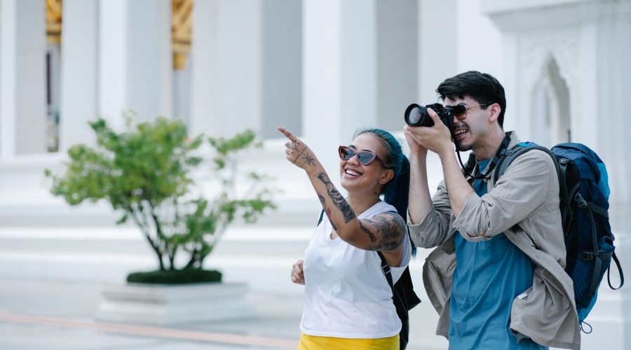 A smiling man and woman explore architectural landmarks with a camera, embracing travel and photography. — Aitutaki Adventure