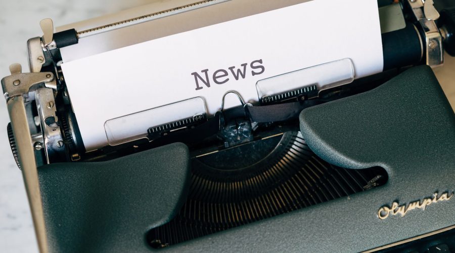 Close-up of a vintage Olympia typewriter with paper reading 'news'. Perfect for classic journalism themes. — Get High Quality