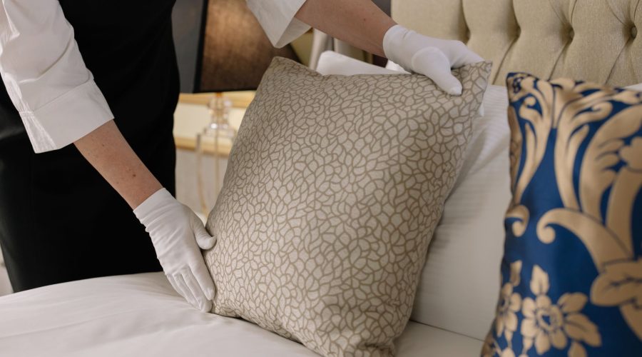 Elegant hotel bedding arrangement by a professional housekeeper in uniform. — Getting Great Festival Accommodation on a tight