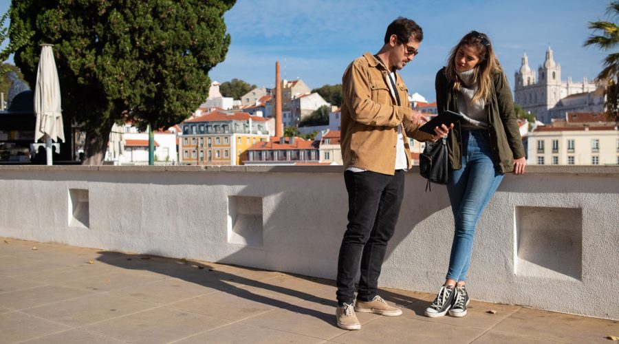 A couple using a tablet in an urban setting with a scenic backdrop, perfect for travel themes. — How To Protect The Car From