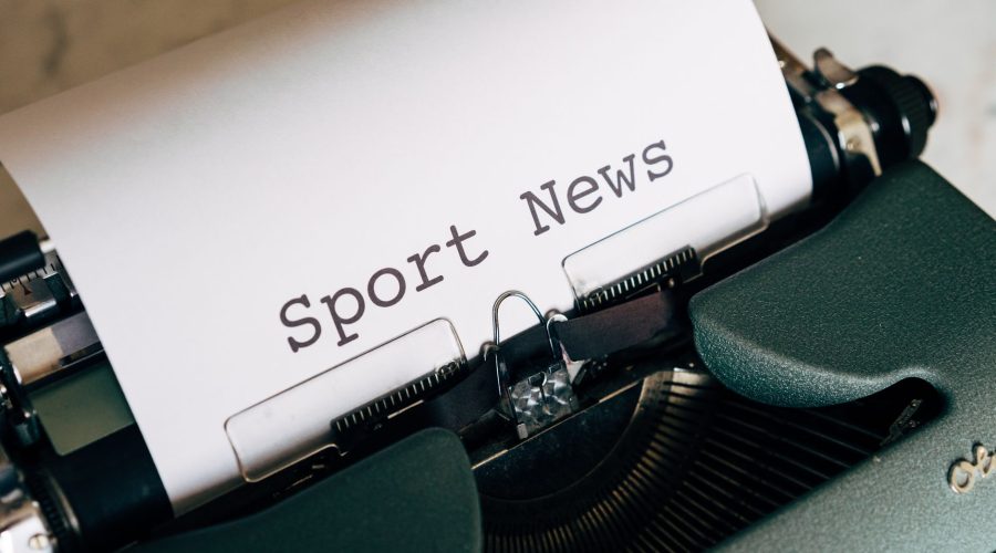 Close-up of a vintage typewriter with 'Sport News' typed on paper, evoking retro charm. — Maximize Visibility with Comprehens