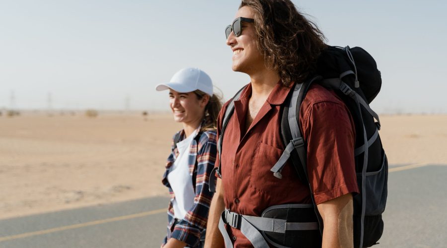 A smiling young couple hikes on a desert road, embodying happiness and adventure. — Passover Vacations 2024: From Beach Resor