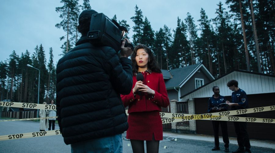 A female journalist reports live from an outdoor crime scene, flanked by police officers and media personnel. — Protecting Yo